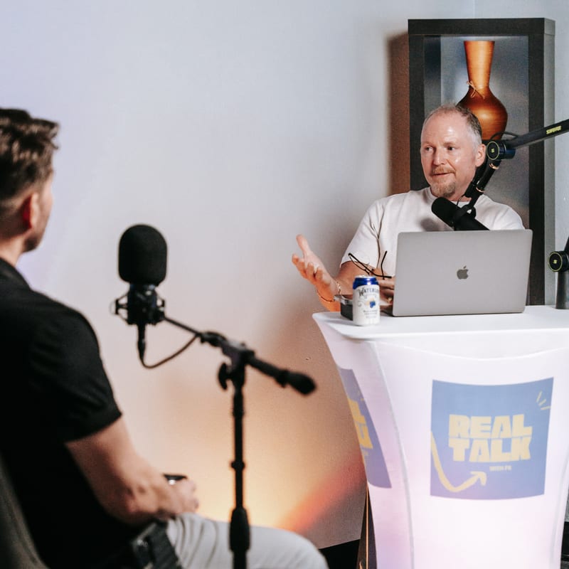 Pastor Ken at the studio table, mid-conversation with a guest