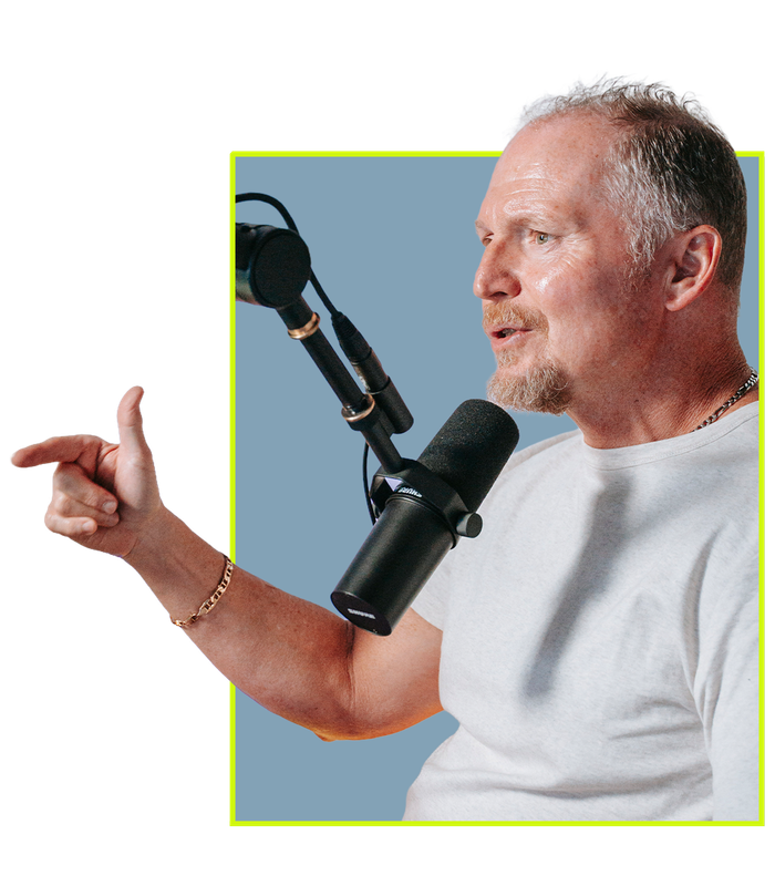 Pastor Ken at the studio mic, mid-conversation, pointing across the table